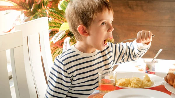 Portrait of little toddler boy eating scrambled eggs with fork for breakfast — Stock Photo, Image