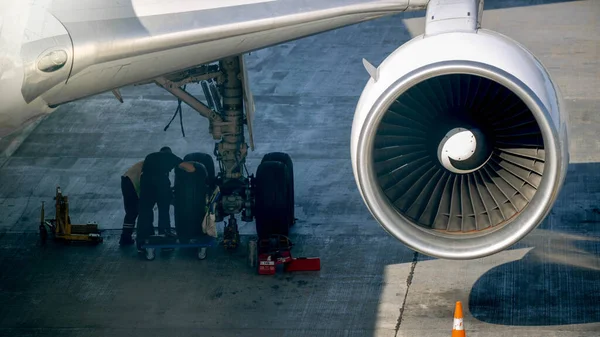 Foto de la tripulación de tierra de Maintenace comprobando el chasis del avión antes del vuelo —  Fotos de Stock