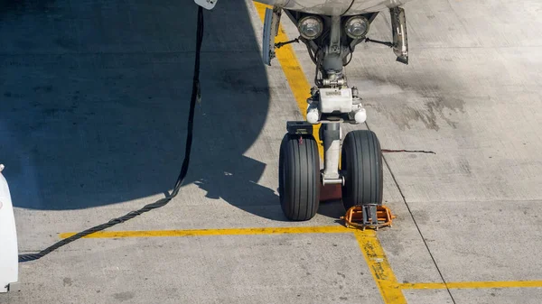 Переднее шасси самолета припарковано в аэропорту во время проверки и обслуживания самолета — стоковое фото