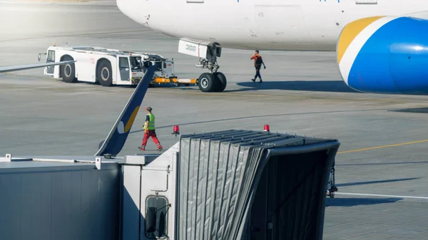 Trattore speciale tirando grande aereo al cancello d'imbarco nel terminal aereo — Foto Stock