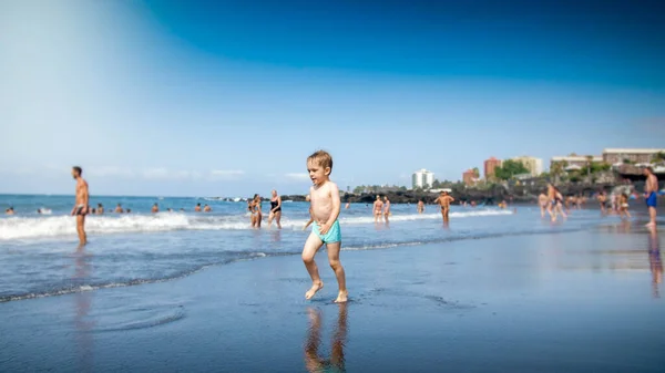 Happy cheerful little boy running on the ocean beach — Stock Photo, Image
