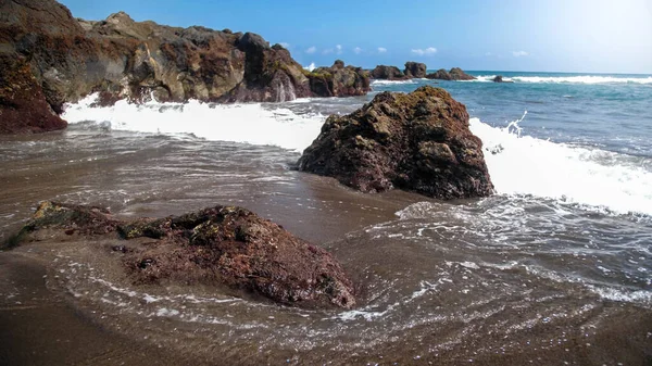 Hermoso paisaje marino de olas oceánicas y rocas en la playa con arena volcánica negra —  Fotos de Stock
