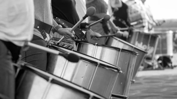 Черно-белый образ уличных музыкантов, играющих на барабанах на городском фестивале или торжествах — стоковое фото