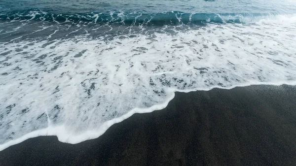 Hermosa imagen de olas azules del océano rodando y rompiendo en la playa con arena volcánica negra — Foto de Stock