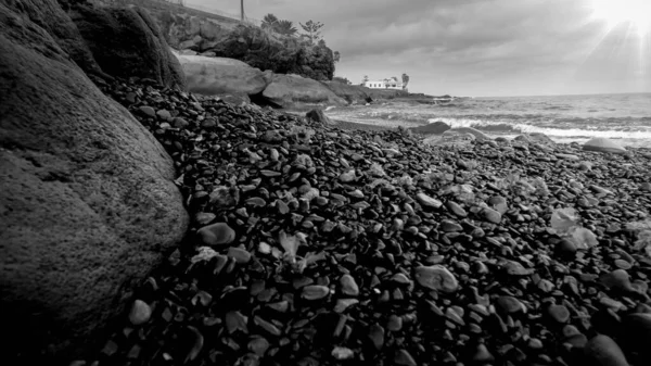 Чорно-біле зображення красивого узбережжя океану з скелястим пляжем — стокове фото