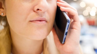 Kafede telefonla konuşan bir kadının yakın plan görüntüsü.