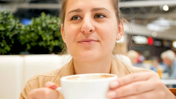 Портрет красивой улыбающейся женщины, держащей чашку кофе в кафе — стоковое фото