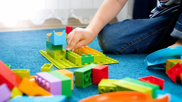 Närbild foto av barn hand montering blind leksak konstruktör och bygga ett hus — Stockfoto