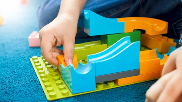 Closeup image of boys hand building toy track using constructor blocks Royalty Free Stock Images