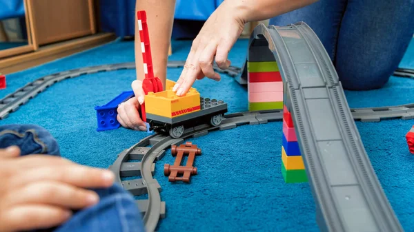 어린 어머니와 함께 기차와 철도를 타고 바닥에서 놀고 있는 모습 — 스톡 사진