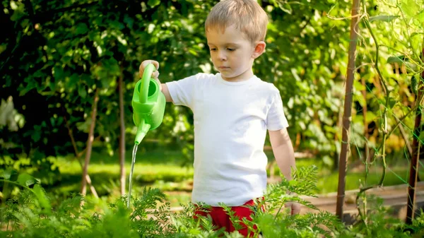 Ritratto di bambino carino con annaffiatoio in giardino — Foto Stock