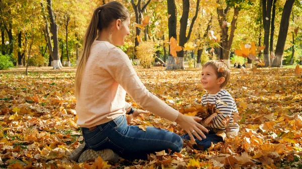 Neşeli çocuk sonbahar parkında annesiyle oynuyor. — Stok fotoğraf