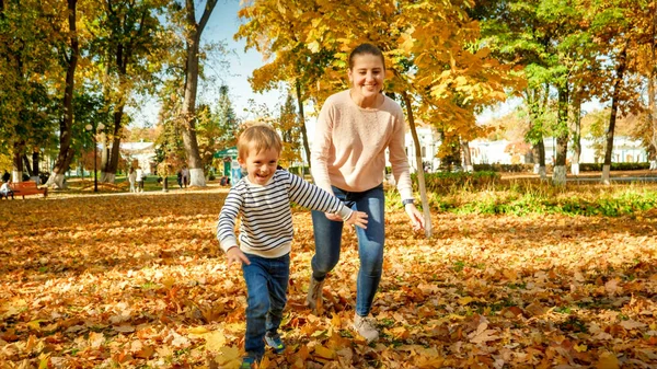 快乐的笑着一家人在秋天的公园里奔跑和哭泣 — 图库照片