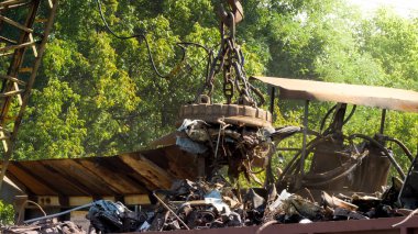 Hurdalıktaki diğer çöplerden metal atıklarını ayıran büyük elektrik mıknatısı