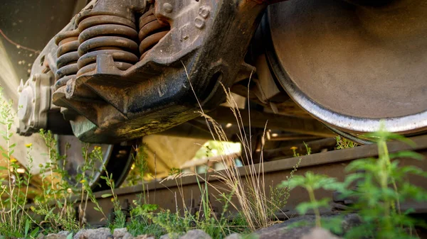 Крупный план старого ржавого вагона на заброшенной железной дороге, заросшей травой — стоковое фото