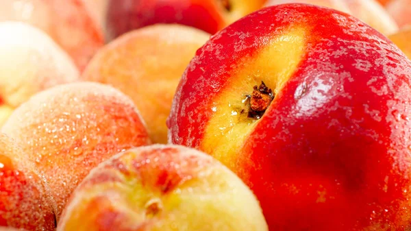 CLoseup photo of big heap of wet cripe peaches and apricots. Abstract background of seasonal fruits — Stock Photo, Image