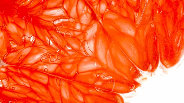 Macro foto de pulpa jugosa de naranja roja o pomelo sobre fondo blanco. Fondo abstracto de frutas tropicales y bayas exóticas —  Fotos de Stock