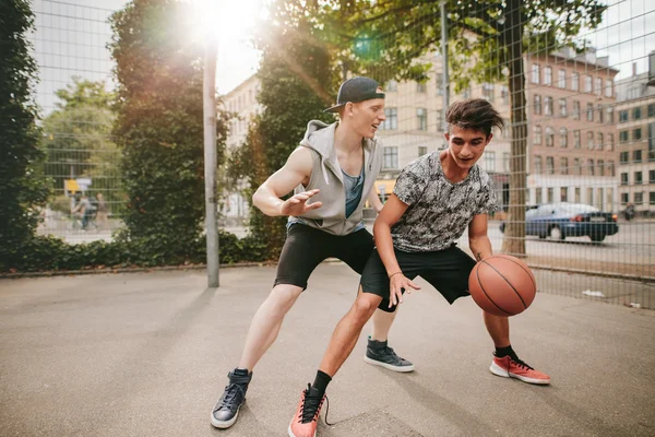 Teenagers playing basketball on outdoor court — Stock Photo, Image