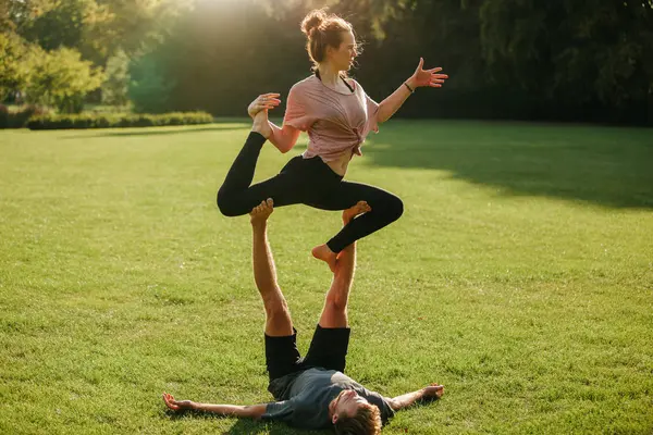 Homem e mulher fazendo várias poses de ioga — Fotografia de Stock