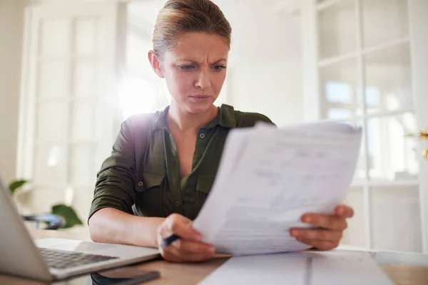 Femme lisant des documents devant un ordinateur portable — Photo