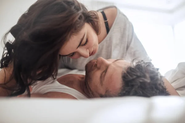 Влюбленная пара, лежащая вместе на кровати — стоковое фото