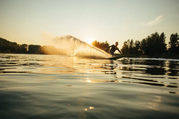 Wakeboarder se movendo rápido em salpicos de água — Fotografia de Stock