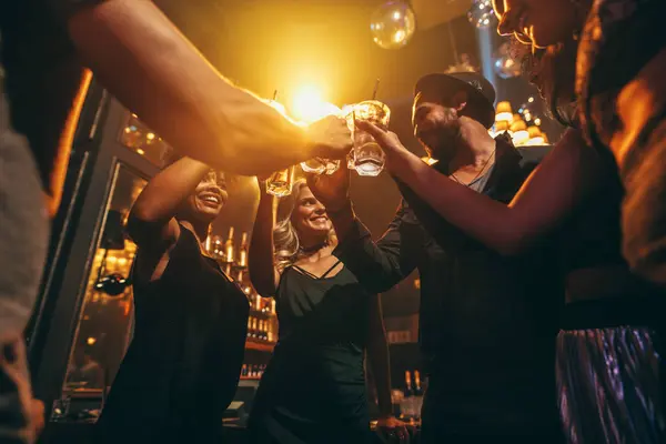 Groep vrienden genieten van drankjes in bar — Stockfoto