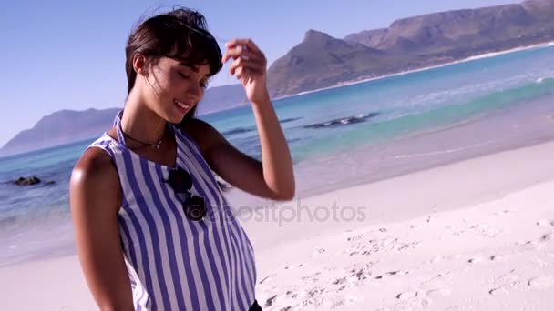 Mujer joven sonriente en la playa — Vídeo de stock
