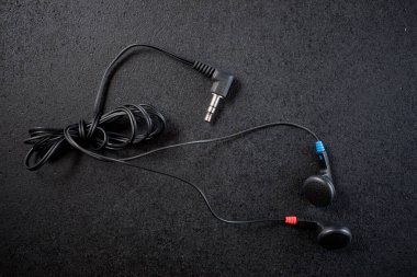 Siyah bir masada küçük kulaklıklar..