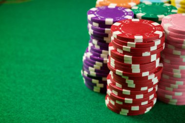 Yeşil hasırlı ve kumarhane fişleri olan bir oyun masası görüntüsü.