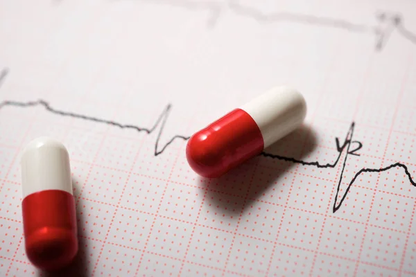 薬と心電図を紙の形で閉じます — ストック写真