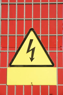 Elektriksel tehlike işareti metal bir çite yerleştirilmiş..