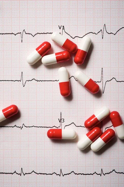 薬と心電図を紙の形で閉じます — ストック写真
