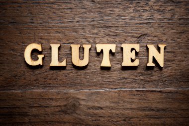 Ahşap bir masada glüten kelimesi.
