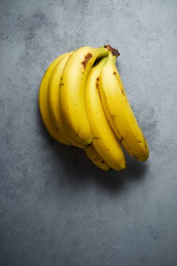 Gri bir masada muzlar.