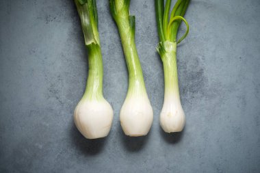 Gri bir masada soğanlar.