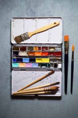 Taş bir masada suluboya kutu.