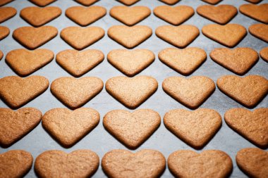 Taş bir masada kalp şeklinde zencefilli kurabiyeler.