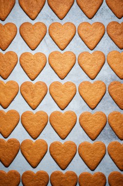 Taş bir masada kalp şeklinde zencefilli kurabiyeler.