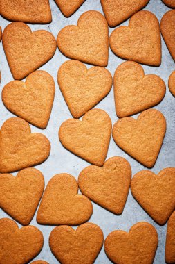 Taş bir masada kalp şeklinde zencefilli kurabiyeler.