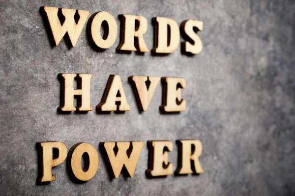 Words have power text on a gray paper.
