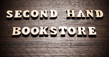 Ahşap bir masada ikinci el kitapçı metni.