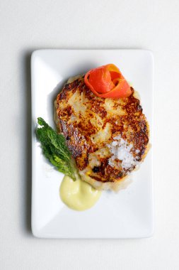 Beyaz tabakta enginar soslu kuzu eti..