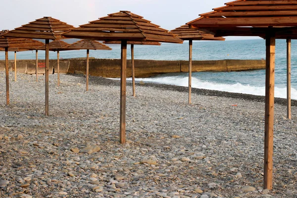 Wooden umbrellas on the beach, umbrellas on the coast — Stock Photo, Image