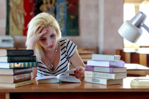 Moe blond, student of schoolmeisje, zorgvuldig op zoek naar het boek — Stockfoto