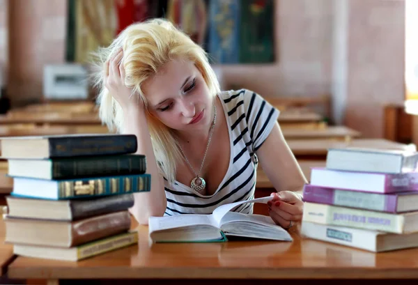 Slordig meisje het lezen van een boek in de tabel — Stockfoto