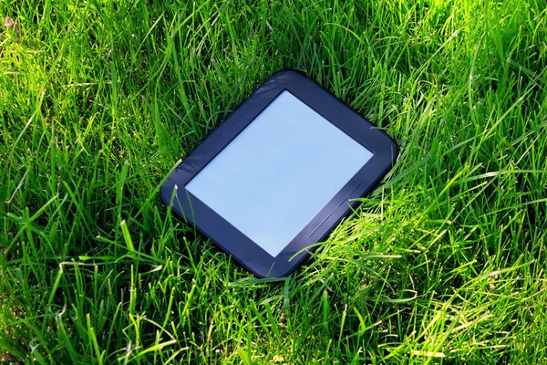 Черная электронная книга на траве — стоковое фото
