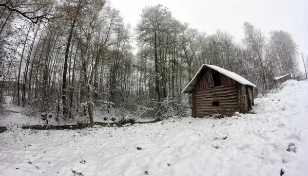 Antiguo baño de madera en las orillas del arroyo en el bosque entre los árboles — Foto de Stock