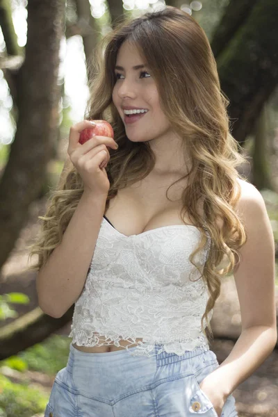 微笑着的年轻女人，吃一个苹果 — 图库照片