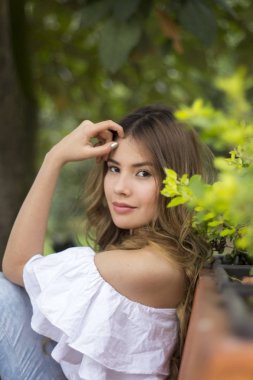 Kameraya bakarak çiçek arkasında güzel bir kadın portresi